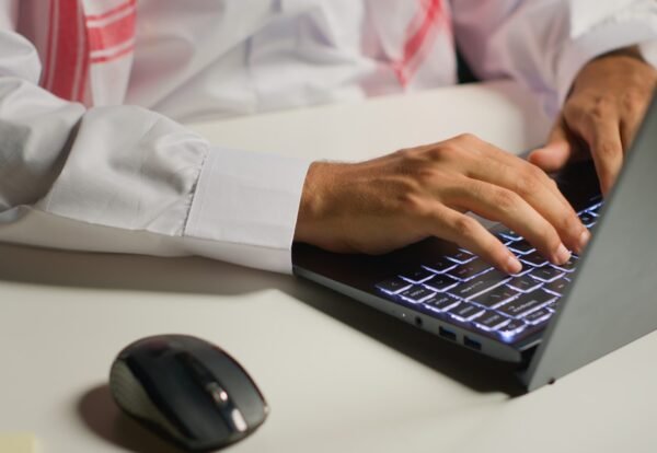 Businessman using laptop and mouse Close up shot of businessman using laptop and mouse in office to solve various work tasks. Employee typing on notepad keyboard in order to deliver finalized project paperwork to management